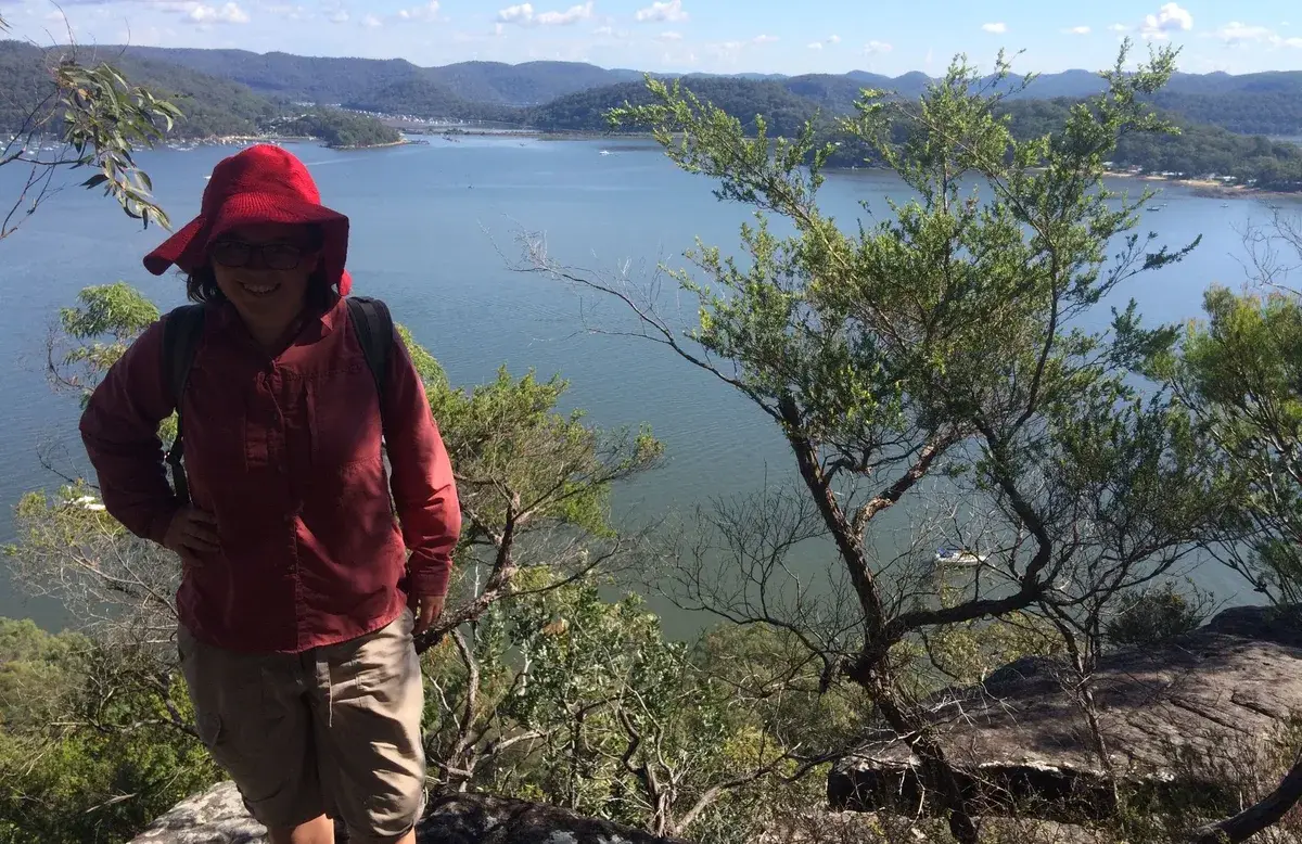 Hiker in a red hat pausing above the Hawkesbury River near Little Wobby