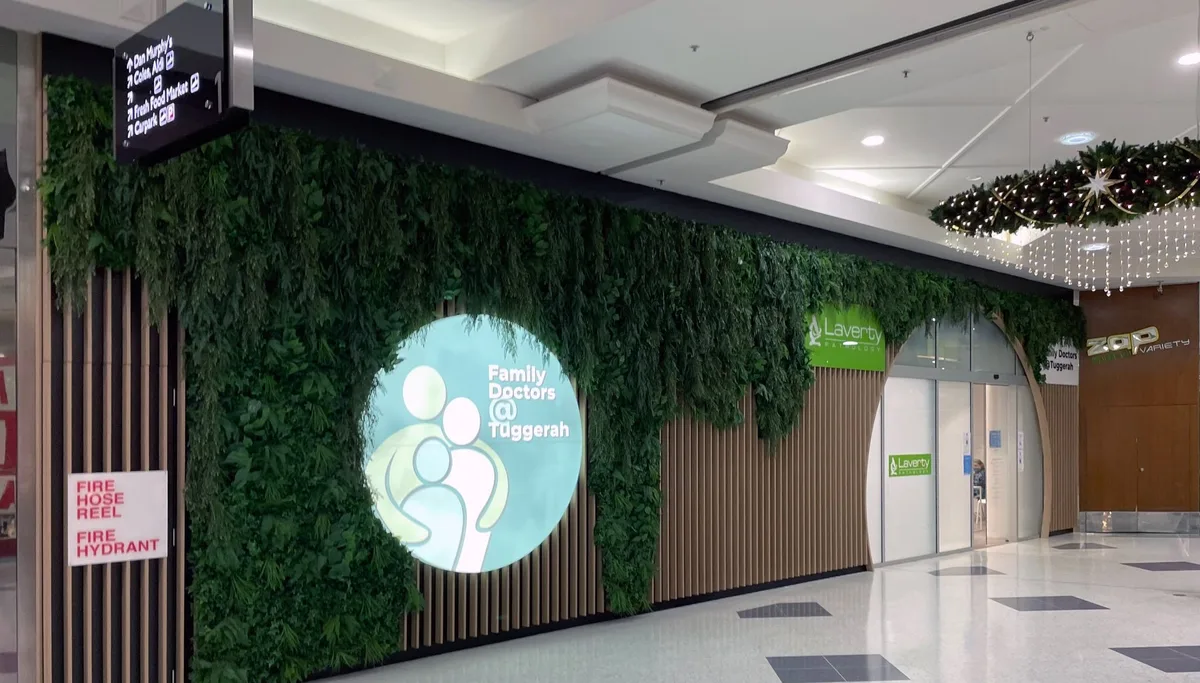Green wall feature and shopfronts inside a Central Coast shopping centre