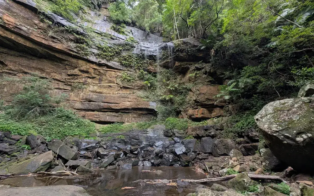 Gap Creek Falls dropping over a layered sandstone cliff into a rainforest pool