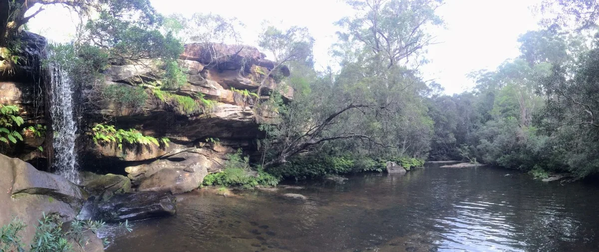 Waterfall spilling into a calm sandstone pool along the Girrakool loop