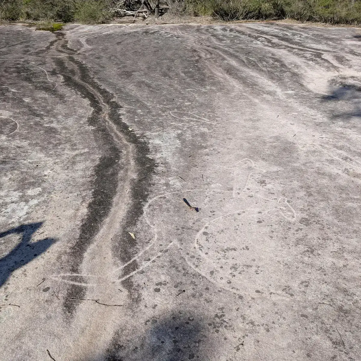 Circular engraving markings faintly visible on the rock platform