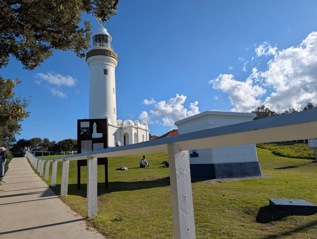 The accessible concrete path and white timber fence leading up to Norah Head Lighthouse