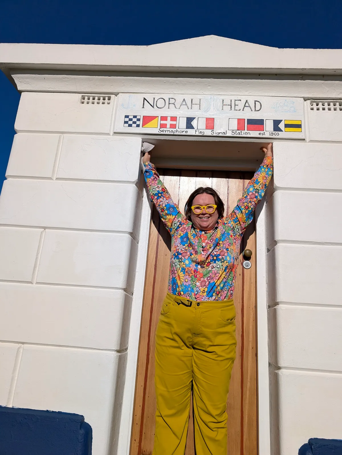 A walker in the doorway of the heritage Norah Head Semaphore Flag Signal Station, established 1903