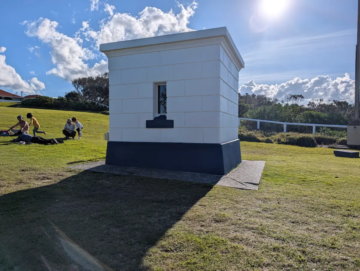 The restored white and navy signal hut on the lawn at Norah Head Lighthouse reserve