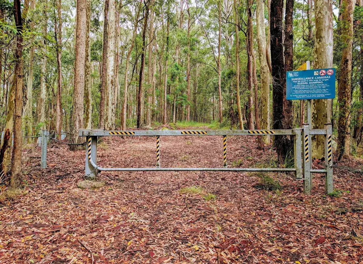 Metal boom gate and dumping warning sign at the firetrail entrance