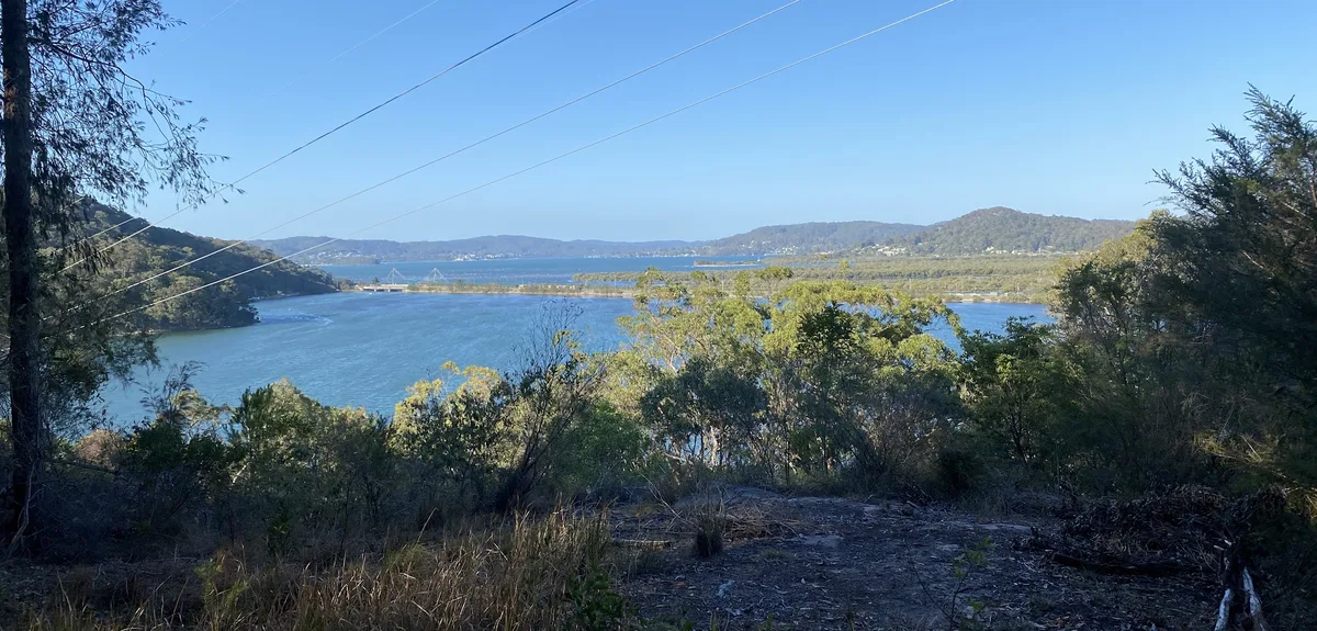 View over Brisbane Water with power lines and distant hills