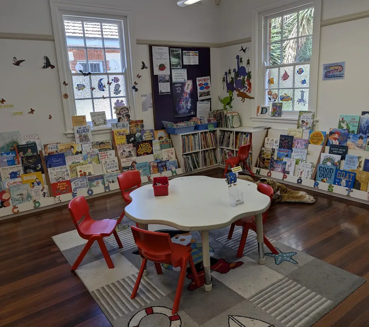 cosy school library corner with reading chairs, picture books and a rug