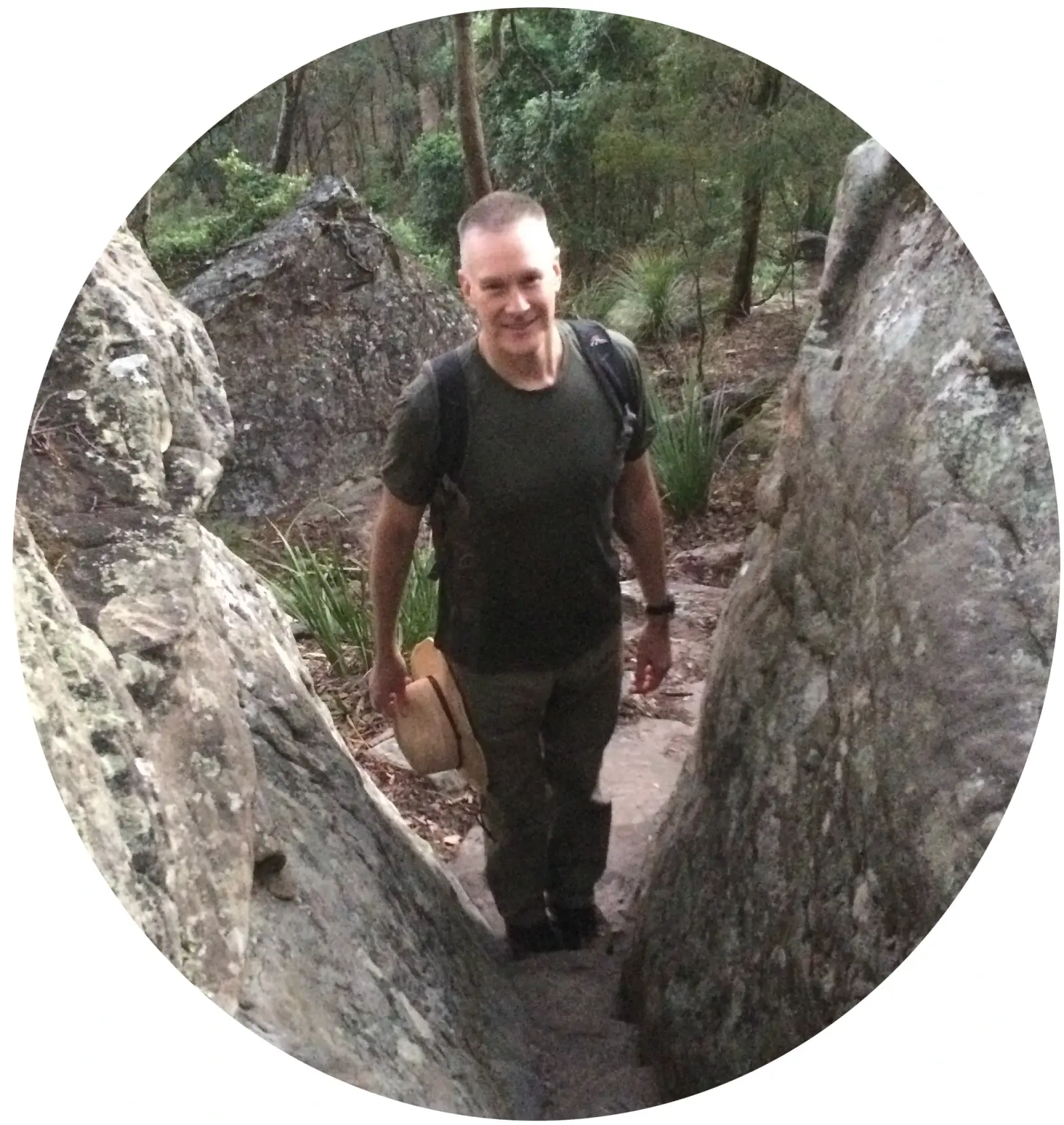 Hiker walking through a narrow sandstone rock crevice