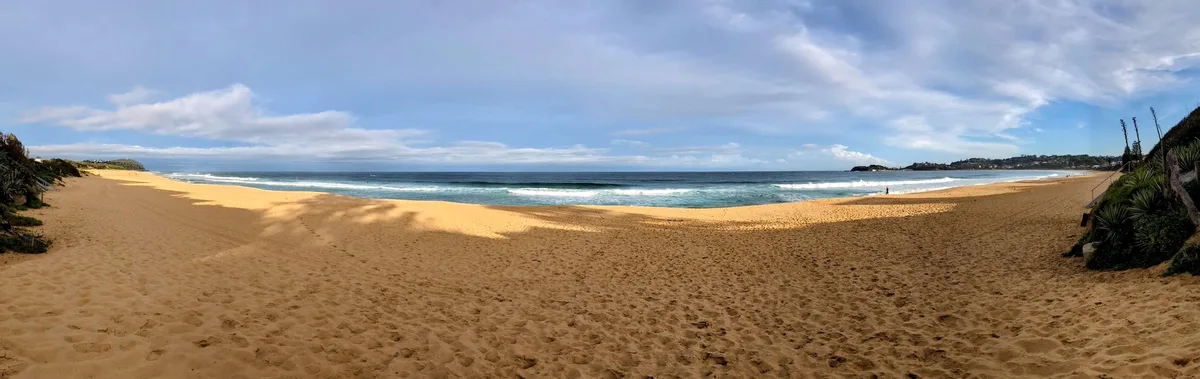 Panoramic view of Wamberal Beach with waves and a distant headland